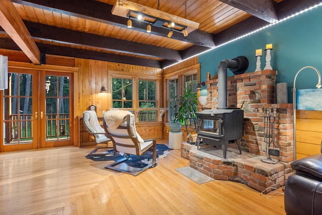 7704 Eastmoore Rd, Shingletown, CA 96088 - living room featuring french doors, wood ceiling, beam ceiling, a wood stove, and wooden walls