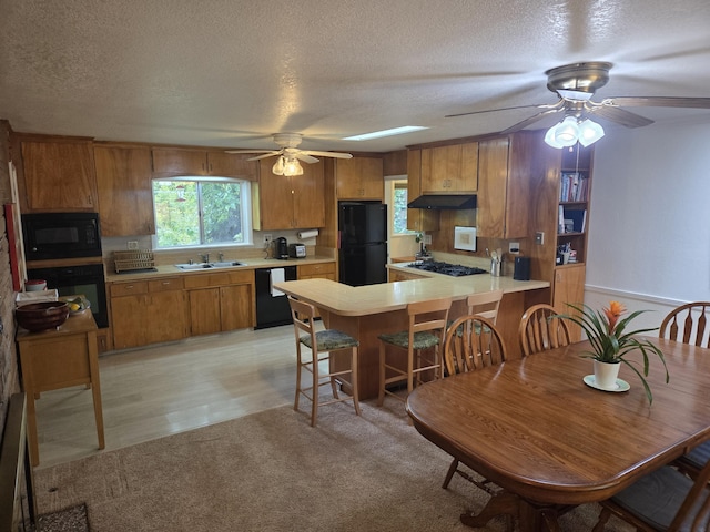 8198 Green Acres Ln, Redding, CA 96002 - kitchen featuring black appliances, a sink, under cabinet range hood, ceiling fan, and brown cabinetry