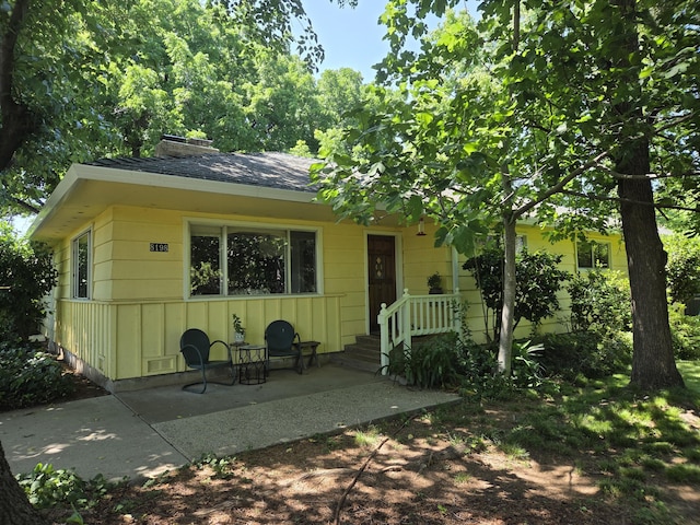 8198 Green Acres Ln, Redding, CA 96002 - view of front of home featuring a chimney, roof with shingles, and a patio area