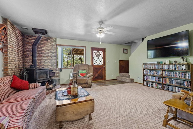7372 Tahoe Ln, Shingletown, CA 96088 - living room with ceiling fan, a wood stove, a textured ceiling, baseboards, and carpet flooring