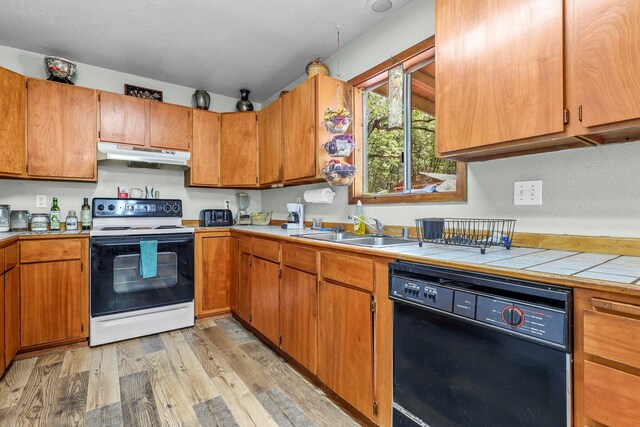 7372 Tahoe Ln, Shingletown, CA 96088 - kitchen with electric range, dishwasher, under cabinet range hood, light wood finished floors, and a sink