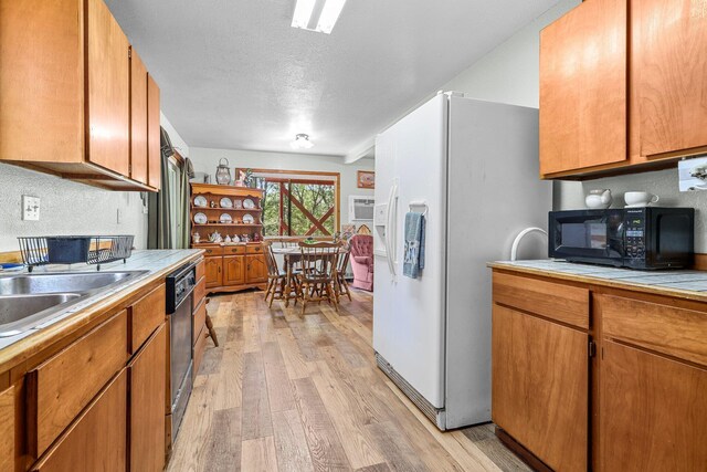 7372 Tahoe Ln, Shingletown, CA 96088 - kitchen with white refrigerator with ice dispenser, black microwave, light wood-type flooring, dishwasher, and tile counters