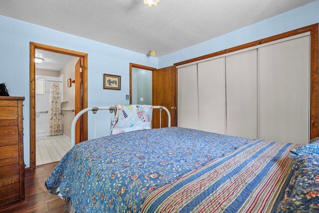 7372 Tahoe Ln, Shingletown, CA 96088 - bedroom with dark wood-style floors, a closet, ensuite bathroom, and a textured ceiling