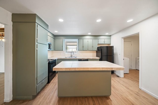 1640 Wisconsin Ave, Redding, CA 96001 - kitchen featuring black appliances, light wood-style flooring, a sink, a center island, and backsplash