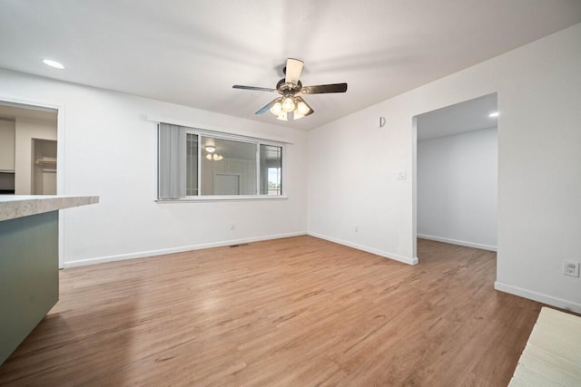 1640 Wisconsin Ave, Redding, CA 96001 - unfurnished living room featuring ceiling fan, baseboards, light wood-style flooring, and recessed lighting