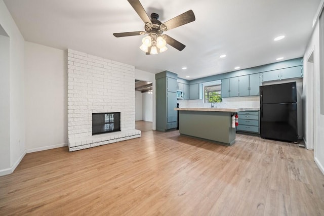 1640 Wisconsin Ave, Redding, CA 96001 - kitchen with freestanding refrigerator, light countertops, ceiling fan, light wood finished floors, and stainless steel microwave