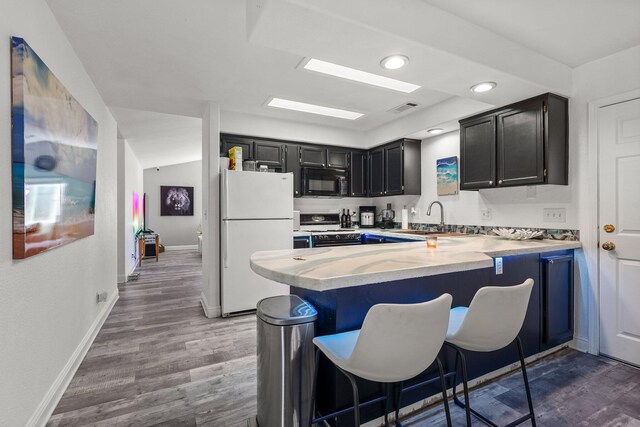 910 Montcrest Dr, Redding, CA 96003 - kitchen featuring freestanding refrigerator, gas range, black microwave, a sink, and a peninsula