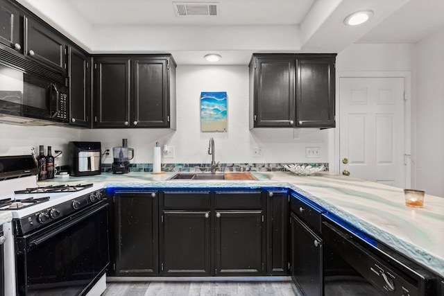 910 Montcrest Dr, Redding, CA 96003 - kitchen with black appliances, dark cabinets, a sink, light countertops, and recessed lighting