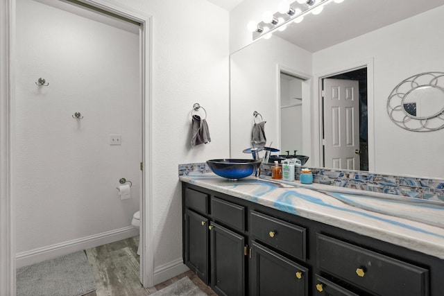 910 Montcrest Dr, Redding, CA 96003 - full bath with wood finished floors, double vanity, toilet, and baseboards