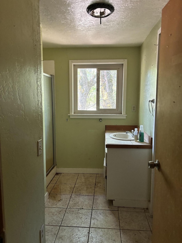 10473 Blue Mountain Ranch Rd, Whitmore, CA 96096 - bathroom featuring vanity, a textured ceiling, a stall shower, baseboards, and tile patterned floors