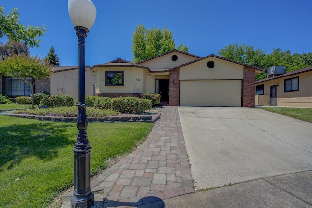 1922 Paris Ave, Redding, CA 96001 - ranch-style home with brick siding, an attached garage, a front yard, and driveway