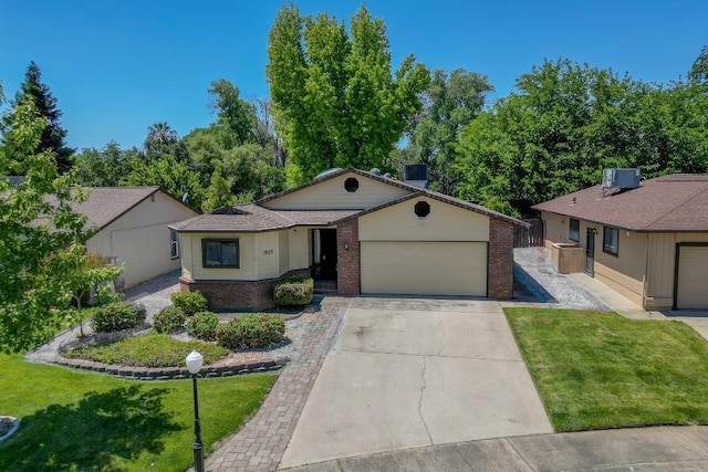 1922 Paris Ave, Redding, CA 96001 - ranch-style house with brick siding, a garage, a front yard, concrete driveway, and central AC unit