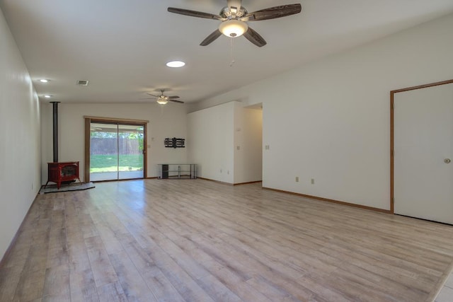 1922 Paris Ave, Redding, CA 96001 - unfurnished living room featuring a wood stove, ceiling fan, light wood finished floors, recessed lighting, and baseboards