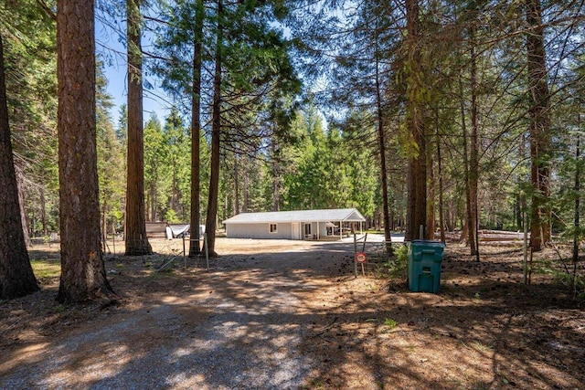 9279 Thatcher Mill Rd, Shingletown, CA 96088 - surrounding community with driveway, a forest view, and a carport