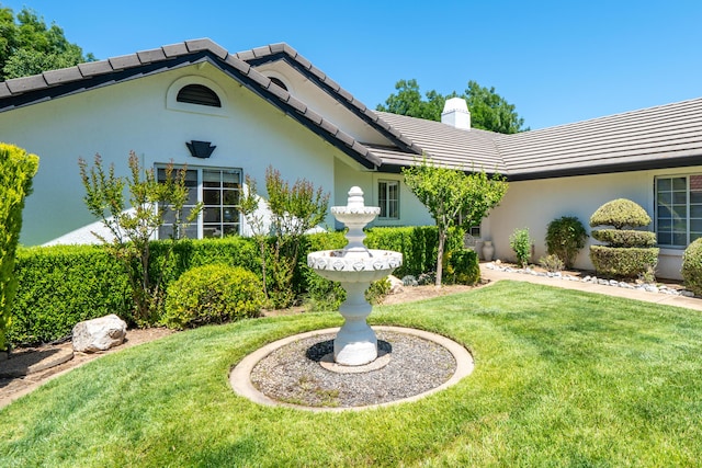 2184 Darsha Ln, Redding, CA 96003 - view of front of home with a front yard, a tile roof, a chimney, and stucco siding