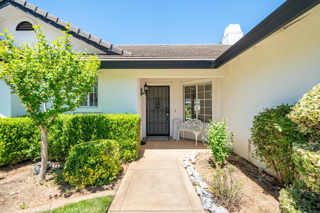 2184 Darsha Ln, Redding, CA 96003 - entrance to property with stucco siding, a chimney, and a tile roof