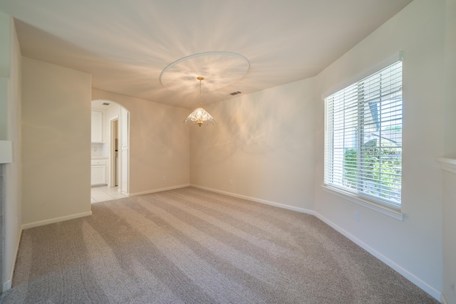 2184 Darsha Ln, Redding, CA 96003 - empty room featuring arched walkways, healthy amount of natural light, light carpet, and baseboards
