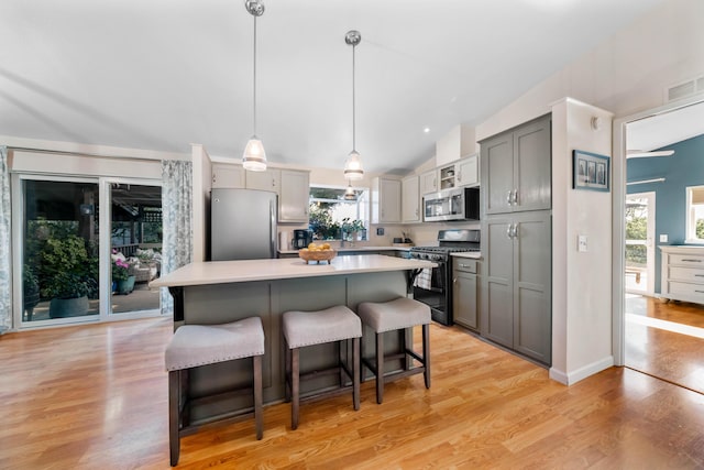 1163 Golden Gate Trl, Redding, CA 96003 - kitchen with appliances with stainless steel finishes, gray cabinets, a breakfast bar, lofted ceiling, and light countertops