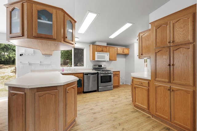 13955 Dusty Oaks Trl, Bella Vista, CA 96008 - kitchen with stainless steel appliances, vaulted ceiling, a peninsula, light wood finished floors, and a sink