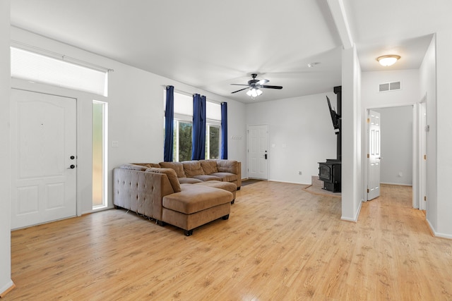13955 Dusty Oaks Trl, Bella Vista, CA 96008 - living area with light wood-style floors, a wood stove, ceiling fan, and baseboards