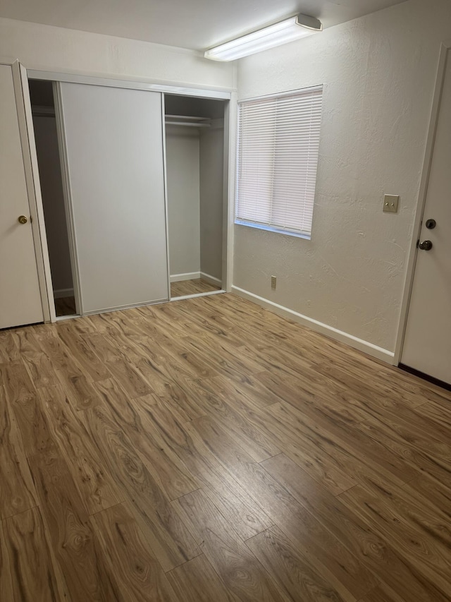 1717 Deer Creek Rd, Shasta Lake, CA 96019 - unfurnished bedroom featuring wood finished floors, a closet, and baseboards