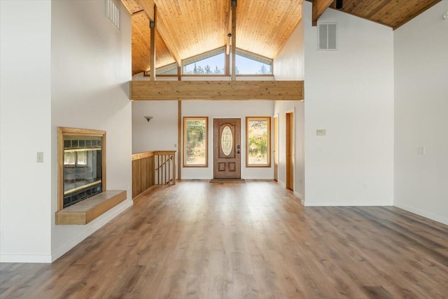 4740 Rainbow, Weed, CA 96094 - unfurnished living room with high vaulted ceiling, wooden ceiling with exposed beams, wood finished floors, baseboards, and a tiled fireplace