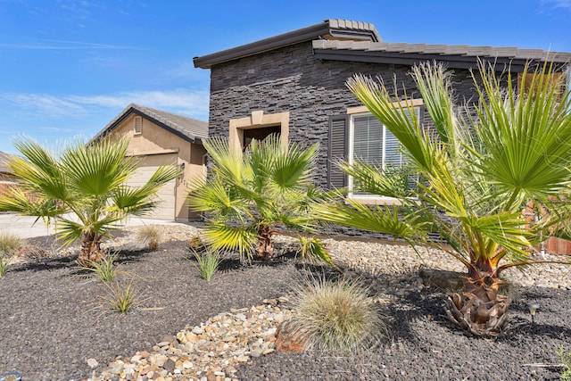 4771 Lower Springs Rd, Redding, CA 96001 - view of property exterior featuring an attached garage, stucco siding, and stone siding