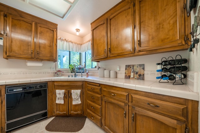 19991 Paso Robles Ave, Redding, CA 96003 - kitchen featuring dishwasher, brown cabinetry, light tile patterned floors, light countertops, and a sink