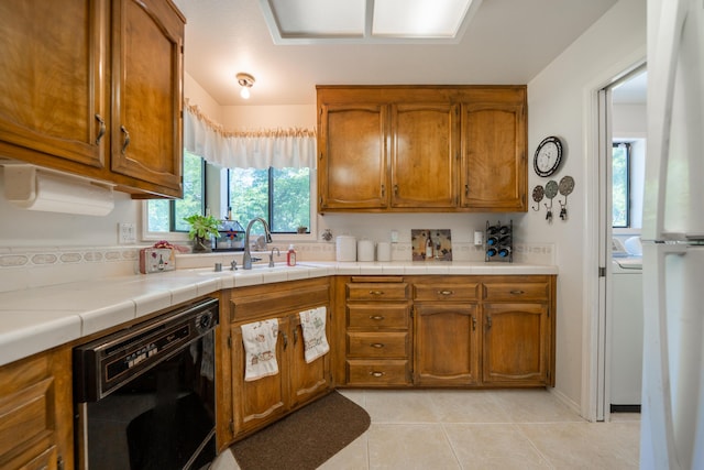 19991 Paso Robles Ave, Redding, CA 96003 - kitchen with dishwasher, brown cabinets, light tile patterned flooring, and a sink
