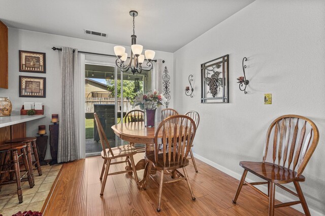 3608 Capricorn Way, Redding, CA 96002 - dining room with light wood-type flooring, a chandelier, and baseboards