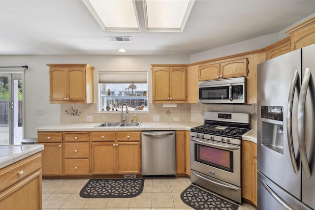 2654 Queens Way, Redding, CA 96001 - kitchen featuring appliances with stainless steel finishes, a sink, tasteful backsplash, tile countertops, and light tile patterned floors