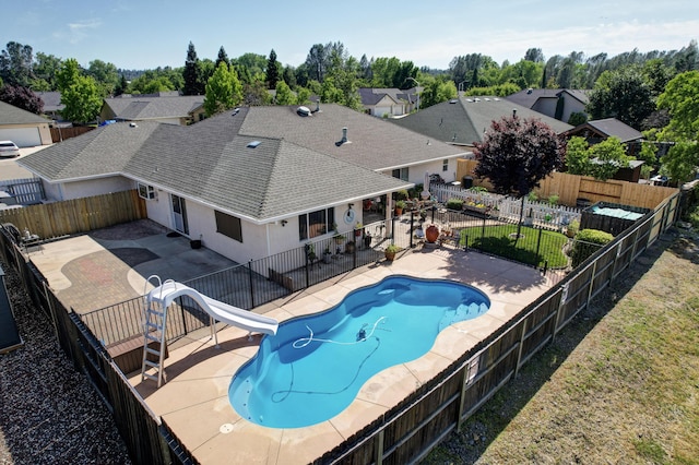 2654 Queens Way, Redding, CA 96001 - view of swimming pool featuring a water slide, a patio area, a fenced backyard, and view of wooded area