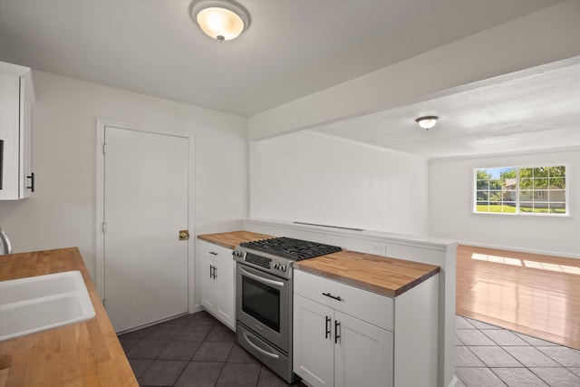 635 Nicklaus Ave, Red Bluff, CA 96080 - kitchen featuring wooden counters, stainless steel gas stove, dark tile patterned flooring, a sink, and white cabinetry