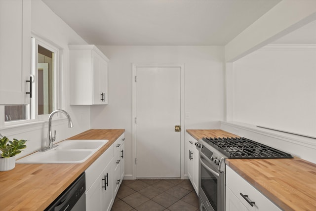 635 Nicklaus Ave, Red Bluff, CA 96080 - kitchen with wood counters, appliances with stainless steel finishes, a sink, white cabinets, and dark tile patterned flooring