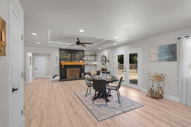 4223 Alta Mesa Dr, Redding, CA 96002 - dining space with baseboards, a fireplace, a raised ceiling, light wood-style flooring, and recessed lighting