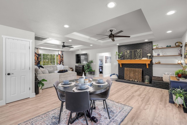4223 Alta Mesa Dr, Redding, CA 96002 - dining area featuring a ceiling fan, a raised ceiling, a brick fireplace, wood finished floors, and recessed lighting