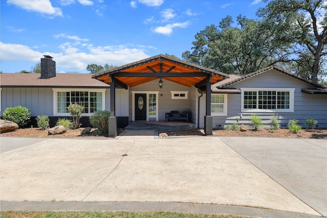 4223 Alta Mesa Dr, Redding, CA 96002 - view of front facade featuring a chimney, covered porch, and board and batten siding