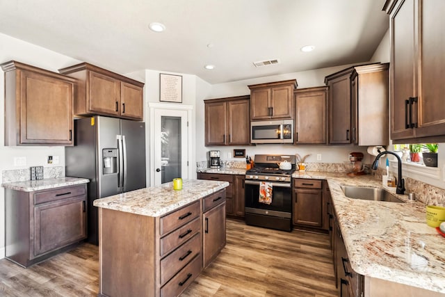 3126 Chaucer Way, Shasta Lake, CA 96019 - kitchen with stainless steel appliances, a sink, a center island, light stone counters, and wood finished floors