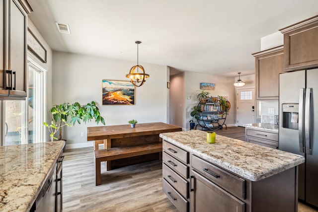 3126 Chaucer Way, Shasta Lake, CA 96019 - kitchen with stainless steel refrigerator with ice dispenser, light wood finished floors, a chandelier, hanging light fixtures, and light stone counters