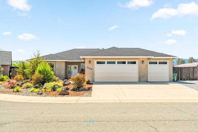 3126 Chaucer Way, Shasta Lake, CA 96019 - view of front of house featuring an attached garage, concrete driveway, stucco siding, and a shingled roof