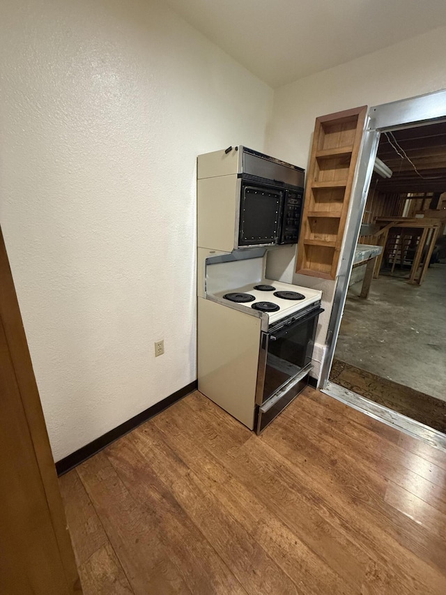 5890 Missouri Ln, Anderson, CA 96007 - kitchen featuring black microwave, electric range oven, wood finished floors, and baseboards