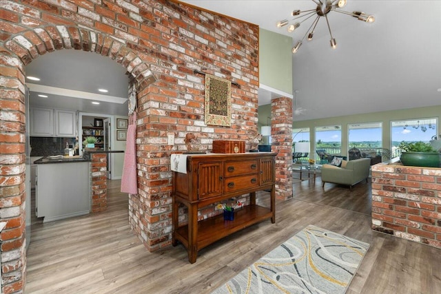 21350 Wilcox Rd, Red Bluff, CA 96080 - living room with light wood-type flooring, ornate columns, arched walkways, a chandelier, and a high ceiling
