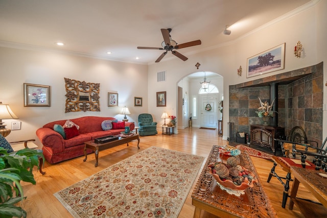 3811 Andes Dr, Redding, CA 96001 - living room with arched walkways, wood finished floors, crown molding, a ceiling fan, and a wood stove