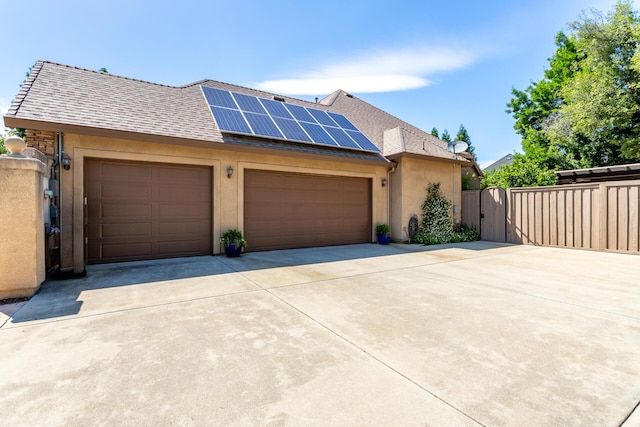 2830 Montana Sky Dr, Redding, CA 96002 - view of front of house with a gate, driveway, stucco siding, solar panels, and an attached garage