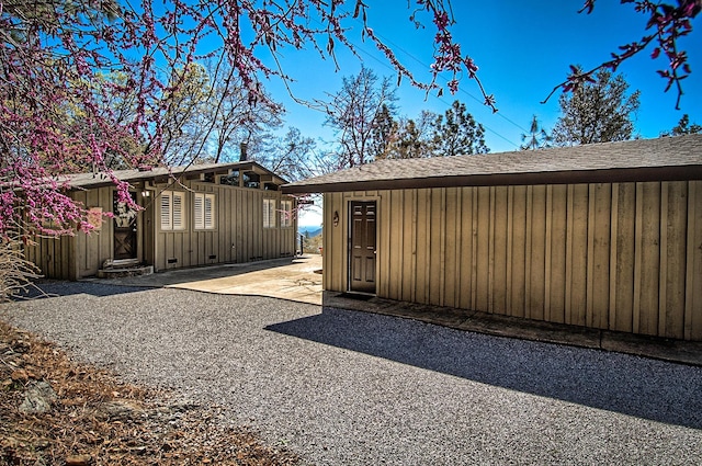 19370 Mountain Maple Rd, Lakehead, CA 96051 - view of side of property featuring an outdoor structure, board and batten siding, a shingled roof, and a patio