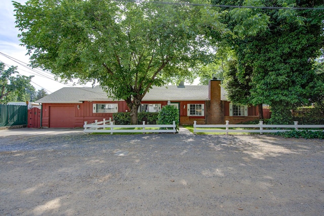 2915 Rockabye Ln, Redding, CA 96002 - ranch-style house with an attached garage, a chimney, concrete driveway, and a fenced front yard