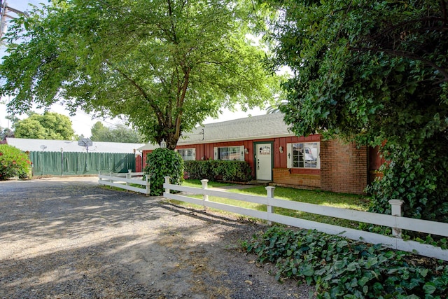 2915 Rockabye Ln, Redding, CA 96002 - view of front facade with a fenced front yard, brick siding, roof with shingles, and board and batten siding