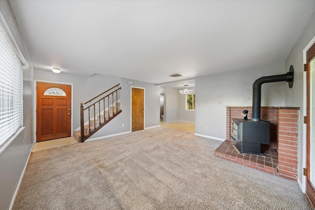 2190 Skyline Dr, Redding, CA 96001 - unfurnished living room with stairs, carpet flooring, a wood stove, and baseboards