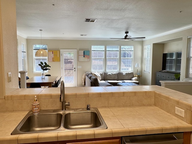 2135 Vienna Way, Redding, CA 96003 - kitchen with tile countertops, open floor plan, ceiling fan, a sink, and ornamental molding
