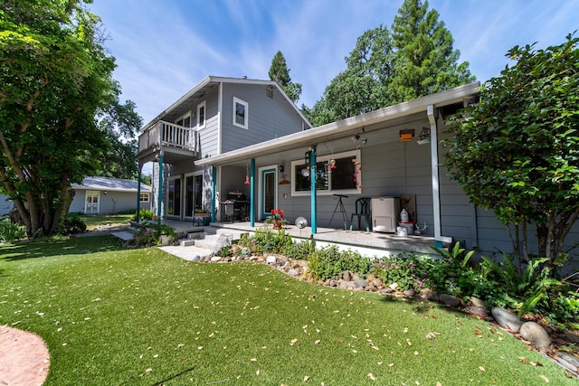 2940 Felstet Ln, Redding, CA 96001 - rear view of property with a balcony, a yard, and covered porch